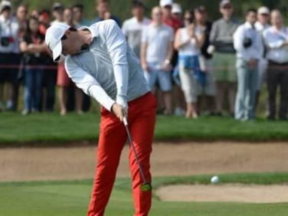 Rory McIlroy strikes his second shot within inches of the cup at the 18th hole during round two of the fog-delayed Abu Dhabi Championship  (Picture: Martin Dokoupil/AP).