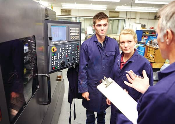 Engineer Teaching Apprentices To Use Computerized Lathe