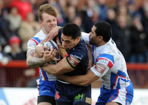 Hull Kingston Rovers Ken Sio holds onto the ball as he is tackled by Wakefield duo Tom Johnstone and Bill Tupou.