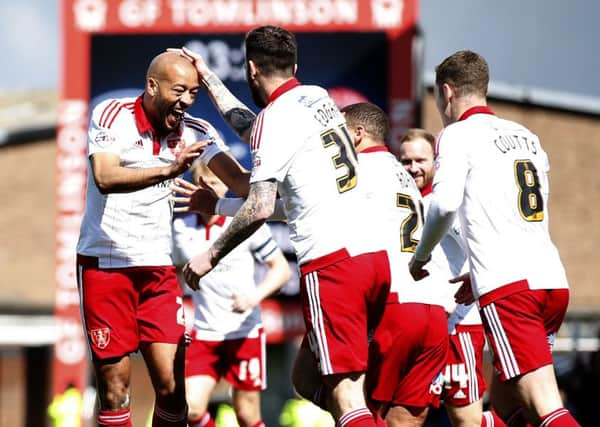 United's Alex Baptiste celebrates his goal.