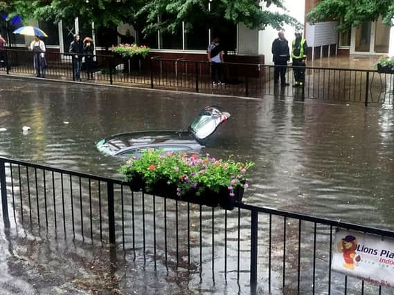 Picture from the Twitter feed of @a_secker of a car submerged in floodwater in Wallington, Surrey.