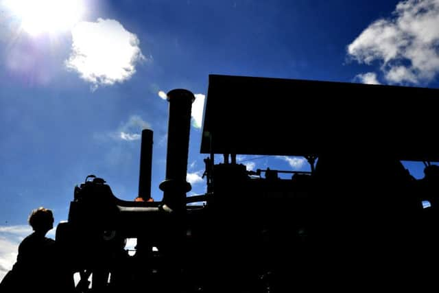 A silhouetted "White Rose," an eight-ton steam roller built by Aveling and Porter in 1915 is being prepared at the Masham Steam Rally.