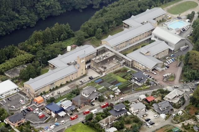 Ambulance vehicles and fire trucks are seen outside a facility. (Kyodo News via AP)