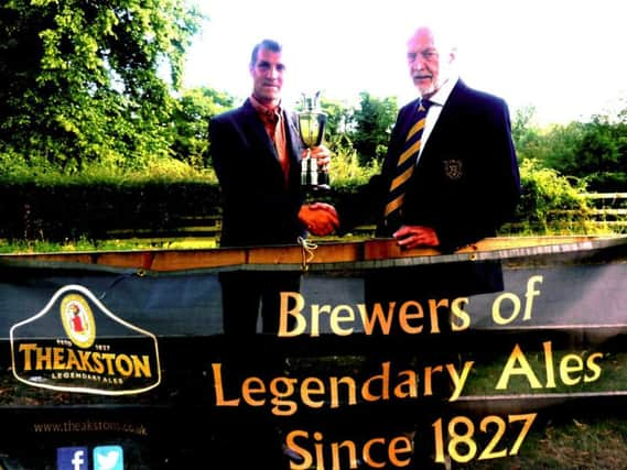 Neil Garbutt receives the Masham Trophy from Harrogate Union president Robin Elias.