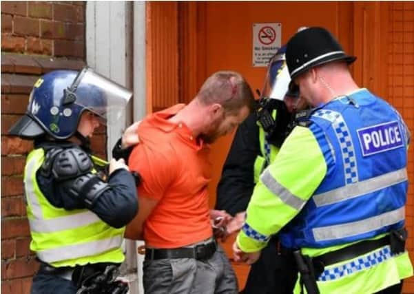 Sheffield United fan Brett Houlsworth from Intake is lead away by officers after throwing a can of Vimto over a police inspector. He admitted the offence at Grimsby Magistrates' Court and was handed a three-year banning order - PICTURE: ROSS PARRY/SWNS