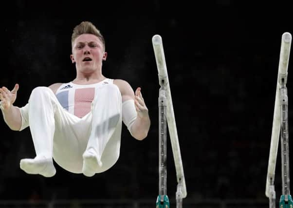 Wilson flies through the air at the end of his horizontal bars routine (PA)