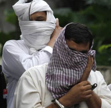 Ex-husband Muhammad Shakeel, front, and father Muhammad Shahid of slain Bradford woman Samia Shahid are escorted by Pakistani police officers to  court