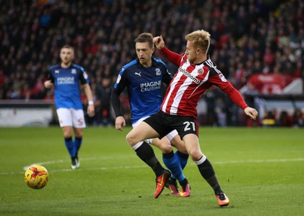 Mark Duffy of Sheffield United - scorer of two goals - tussles with Luke Norris of Swindon Town earlier today. Picture: Simon Bellis/Sportimage