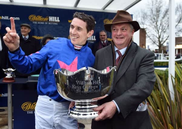 Jockey Paddy Brennan (left) and trainer Colin Tizzard celebrate after winning the King George VI Steeple Chase with Cue Card. Picture: Andrew Matthews/PA.