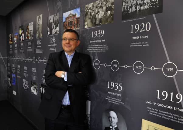 Richard Leach Managing Director of Leach Design in Huddersfield  alongside the company's timeline in the boardroom.