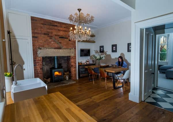 Lucy in the kitchen of her home. Copper chairs from Heal's