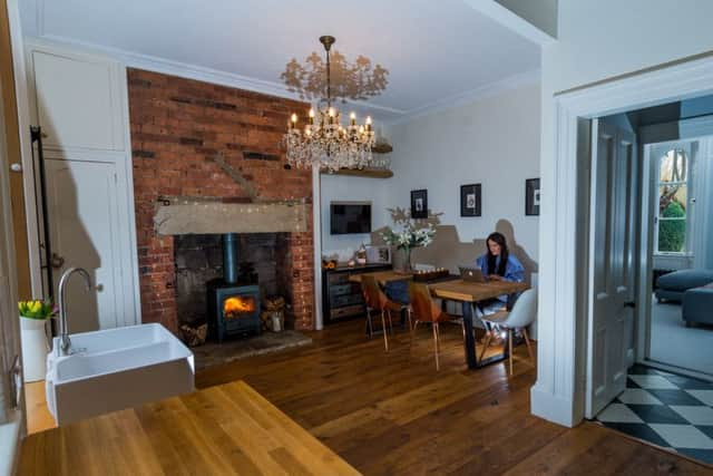 Lucy in the kitchen of her home. Copper chairs from Heal's