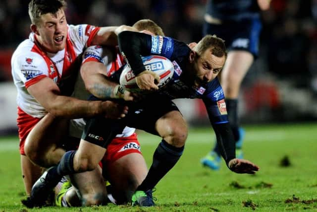 St Helens defence double their efforts to hold back Leeds Rhinos Rob Burrow, who was making his 500th career appearance for the club (Picture: Jonathan Gawthorpe).