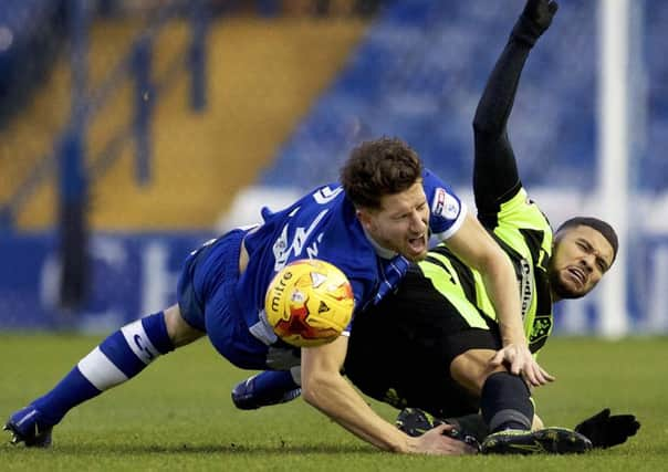 BATTLE: Sheffield Wednesday's Sam Hutchinson tussles with Huddersfield Town's Nahki Wells. Picture: Steve Ellis