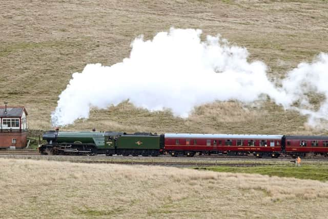 The Flying Scotsman crosses the Ribblehead viaduct in North Yorkshire, as the Settle-Carlisle railway line reopens after floods.