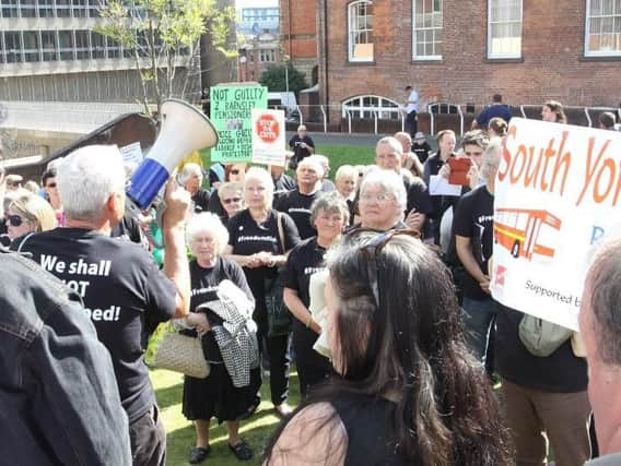 People protest against the arrest of two people during a demonstration about cuts to free travel for pensioners.