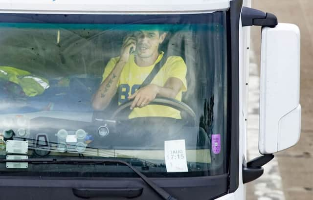 A lorry driver uses a mobile phone as he drives near junction 46 of the M1 in Yorkshire.  Police and motoring experts have warned that attitudes need to change to reflect the fact that such distractions, even for a few seconds, can have fatal consequences.