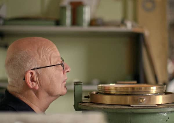 Brian Walker examines one of his hand made compasses.  (C) BBC - Photographer: Glen Milner