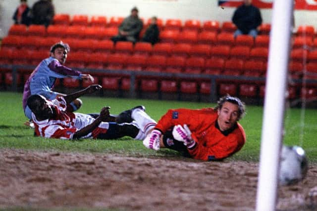 Emley's Deinol Graham slots in what should have been Emley's winning goal past Lincoln's Barry Richardson and Dean Walling.