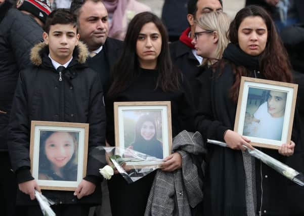 People carry photos of victims as they leave after the Grenfell Tower National Memorial Service at St Paul's Cathedral in London, to mark the six month anniversary of the Grenfell Tower fire. Meanwhile will lessons be learned as building regulations come under scrutiny?