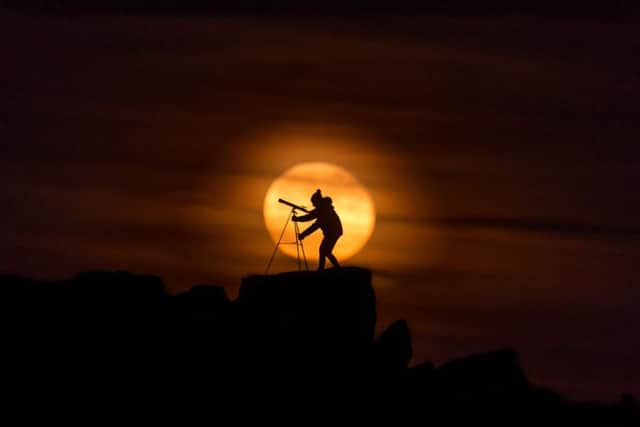 Amateur astronomer Claire Newman, of Fulneck, Pudsey, looking skywards through her telescope at the Cow & Calf Rocks in Ilkley. Picture by James Hardisty.