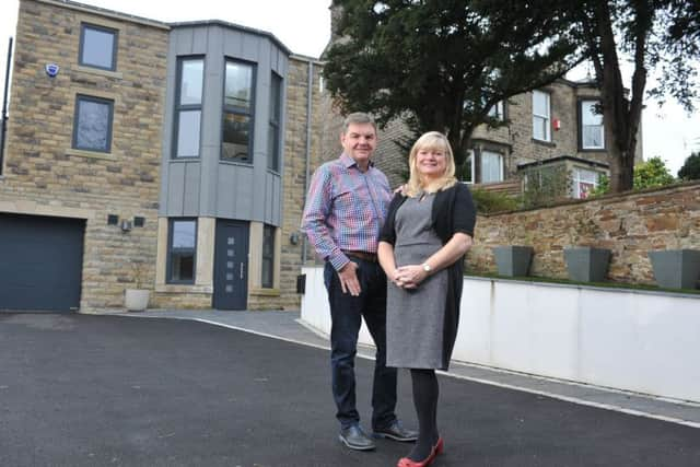 Brian and Linda outside their self-build home wth their former home, right.