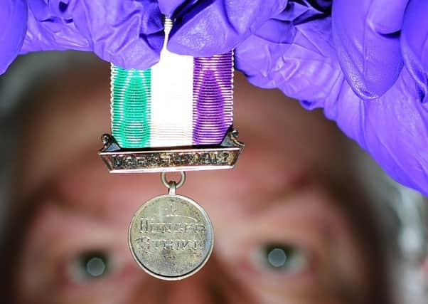 Richard High with a rare women's hunger strike medal from 1912. (Picture by Simon Hulme).