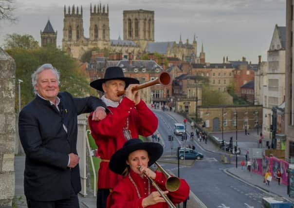 James Cundall, chief exective, of Lunchbox Theatre Production Limited, with two members of the York Waits, on the York Bar Walls.