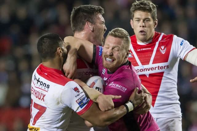 Hull FC's Chris Green is tackled by St Helens's Dominique Peyroux & Morgan Knowles.