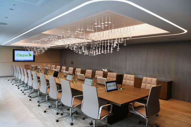 The boardroom with the Â£200,000 walnut desk with gold inlay designed by Emma Bannett. The chairs are by Knoll and the light is bespoke and represents the Clipper plc wave logo