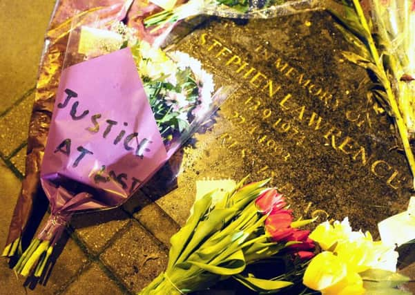 Flowers and tributes on the memorial stone to Stephen Lawrence.