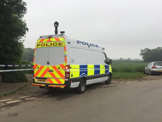 Police near the scene in Aldborough, Boroughbridge where a helicopter crashed in a field. PA photo